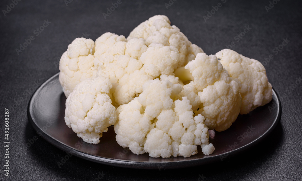 Beautiful swing of fresh white cauliflower on a dark concrete background Beautiful swing of fresh white cauliflower on a dark concrete background