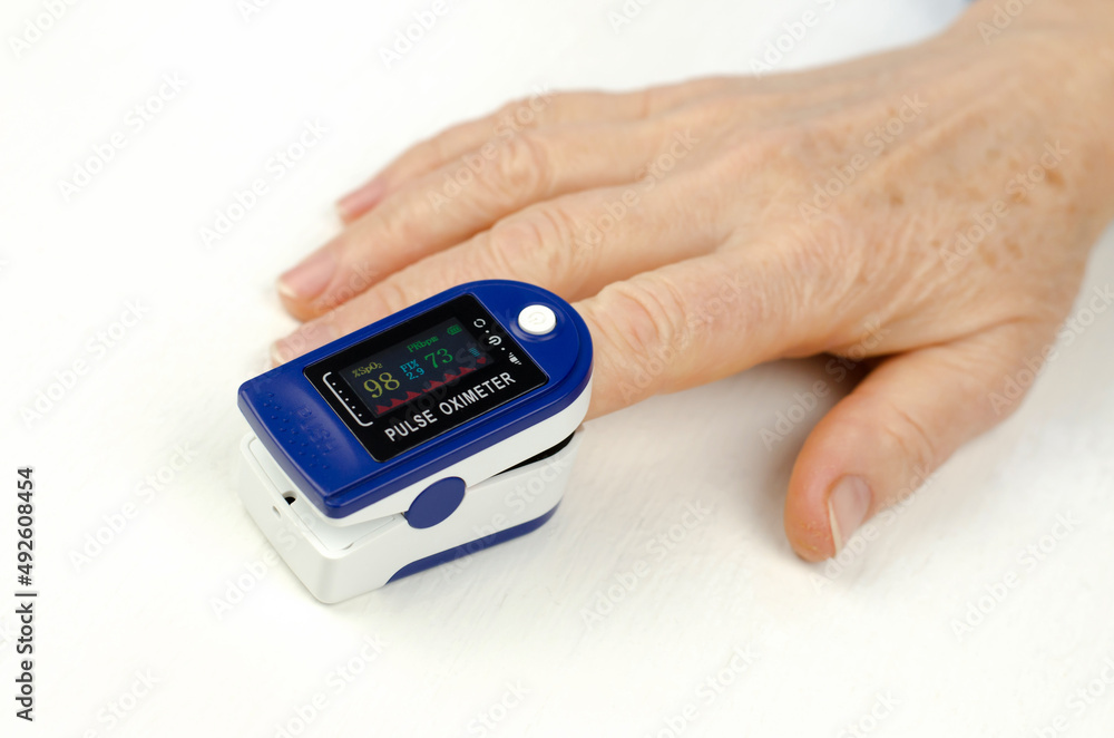 Pulse oximeter on the finger of an elderly woman. Measurement of saturation in a 60-year-old woman. Health care for the elderly. Pulse oximeter on the finger of an elderly woman. Measurement of saturation in a 60-year-old woman. Health care for the elderly.