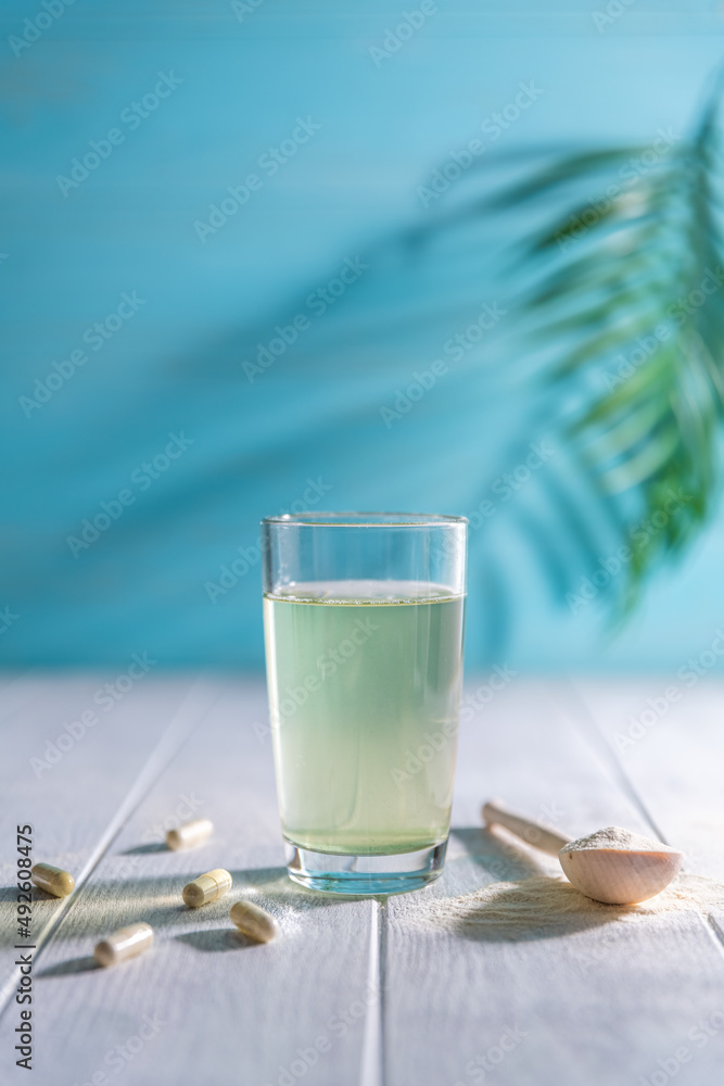 Collagen powder is add to glass of water with a spoon Collagen powder is add to glass of water with a spoon