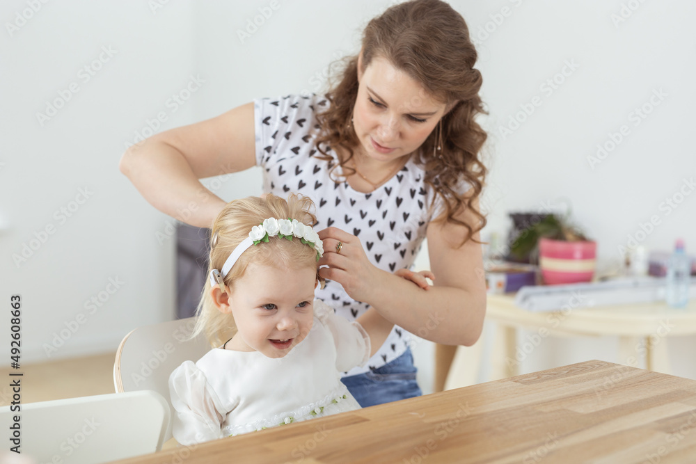 Mother helps to put on cochlear implant for her deaf little daughter. Hearing aid and deafness concept Mother helps to put on cochlear implant for her deaf little daughter. Hearing aid and deafness concept