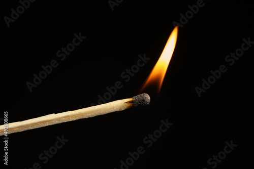 Lighted match on black background