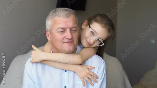 Family portrait of mature father and little blonde daughter hugging at home while celebrating father's day