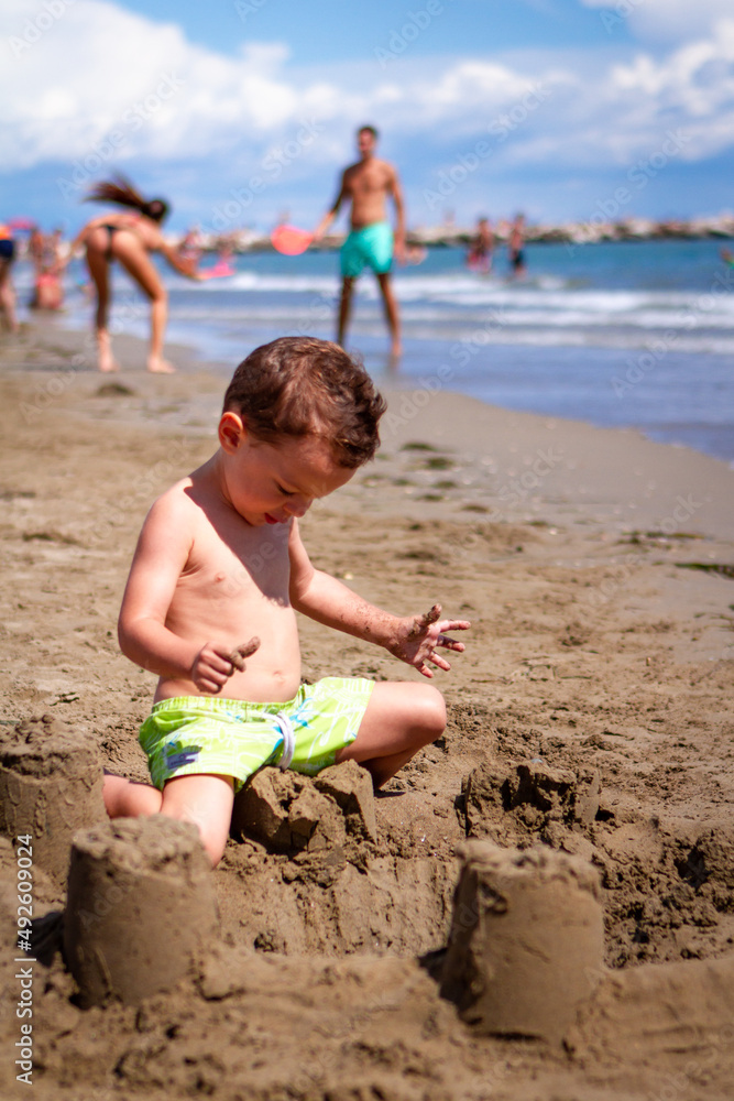 Side view of a caucasian children playing on the shore in swimwear Side view of a caucasian children playing on the shore in swimwear