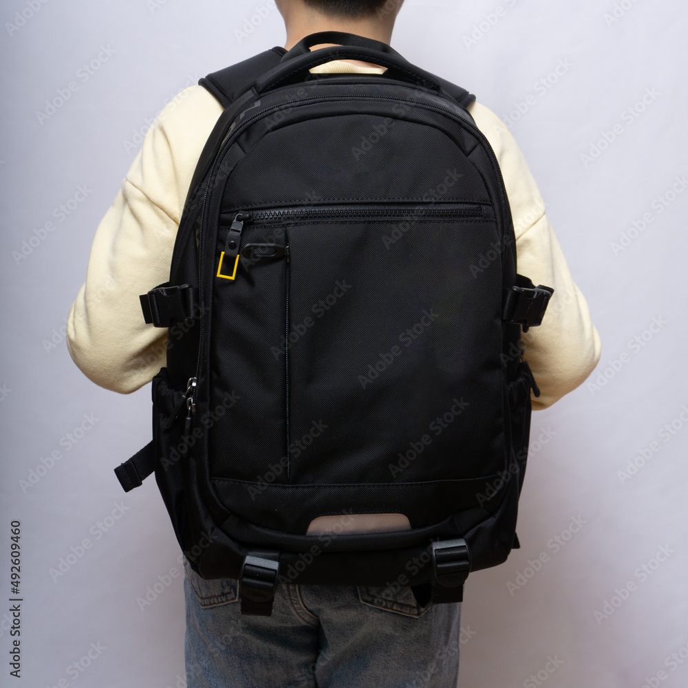 Asian child standing with a black backpack Asian child standing with a black backpack