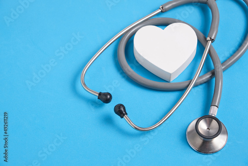White heart and stethoscope on blue background.Heart disease, medical examination.