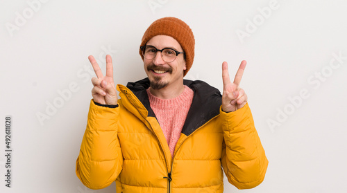 young handsome man with a coat against white wall photo