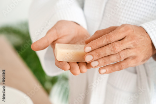 Young man with soap in bathroom, closeup