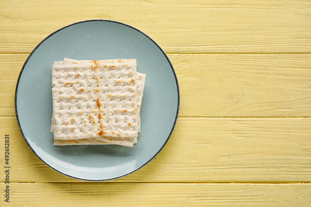 Plate with Jewish flatbread for Passover on color wooden background