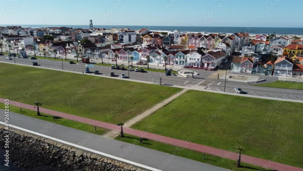 Aerial shot of coloured houses in Costa Nova do Prado in Portugal, Starts above the river and flying towards the houses.In the back you can see the Atlantic ocean. Europe, Aveiro Aerial shot of coloured houses in Costa Nova do Prado in Portugal, Starts above the river and flying towards the houses.In the back you can see the Atlantic ocean. Europe, Aveiro