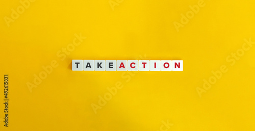 Take Action on Letter Tiles on Yellow Background. Minimal Aesthetics.