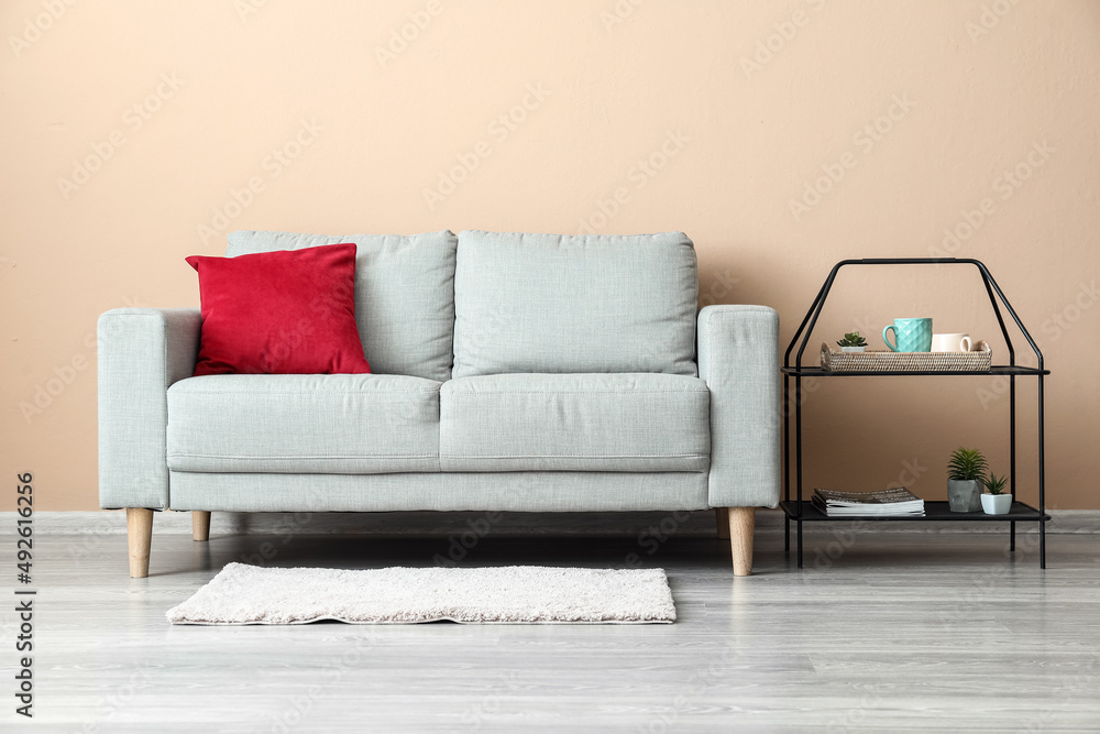 Stylish sofa and table near beige wall Stylish sofa and table near beige wall