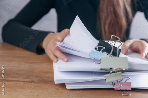 woman checks papers in front of the table. photo