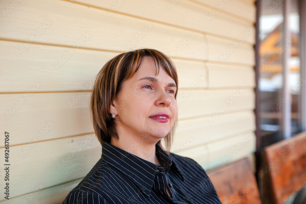 Portrait of beautiful mature woman on porch of her house Portrait of beautiful mature woman on porch of her house