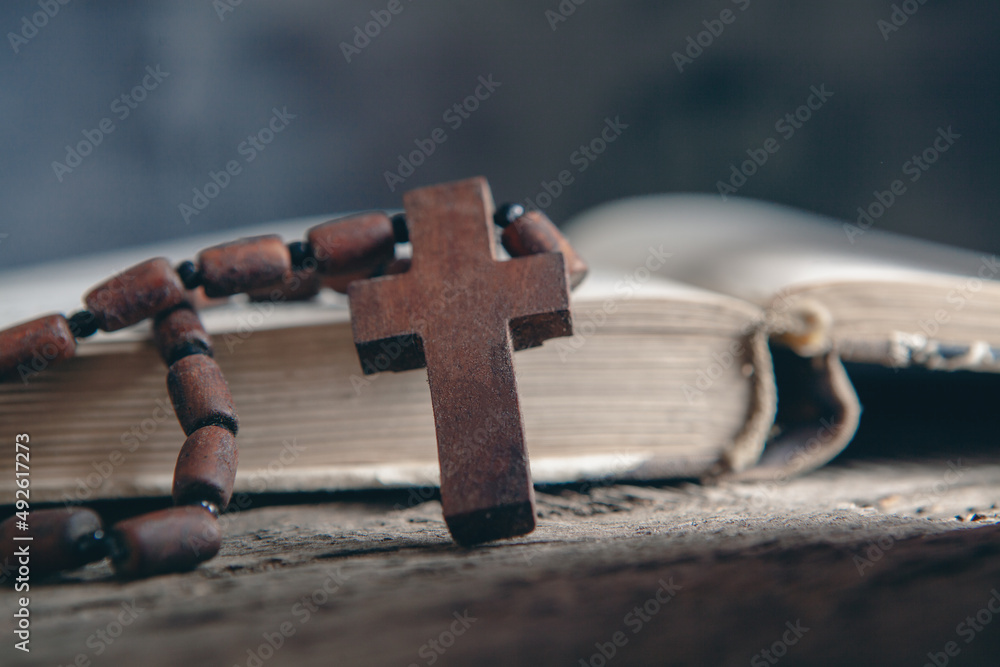 Naklejka premium wooden cross on the book