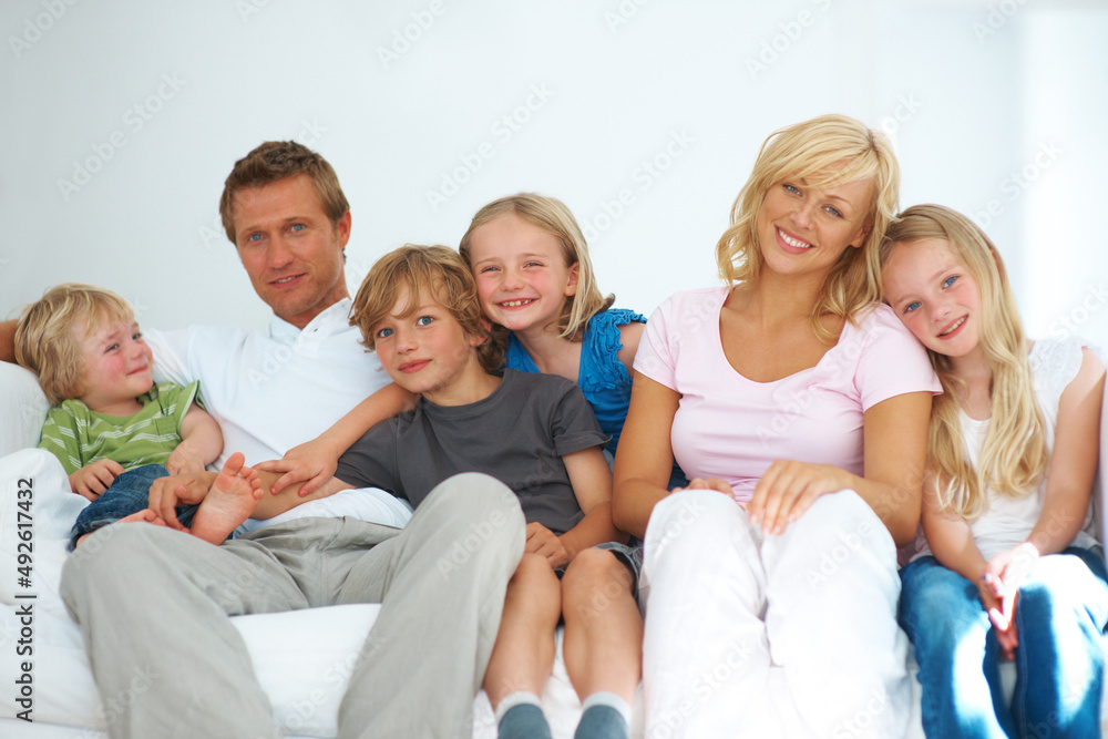 What a loving family. Happy young family sitting on a sofa together at home. What a loving family. Happy young family sitting on a sofa together at home.