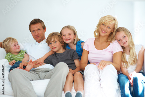 What a loving family. Happy young family sitting on a sofa together at home.