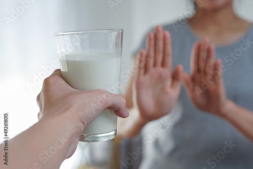Woman refusing or reject glass of milk, Lactose intolerance and health care concept photo
