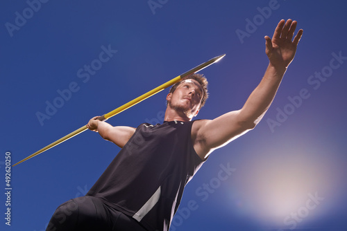 this is going the distance. Shot of a lone man throwing a javelin outside.