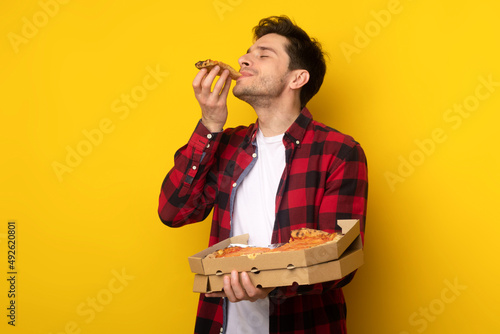 Happy Guy Holding Box Biting Pizza At Studio photo