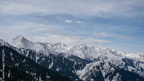 Blue sky with clouds over snowy peaks © Daniil_98_03_09