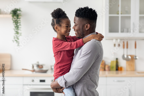 Loving black father holding his little daughter on hands