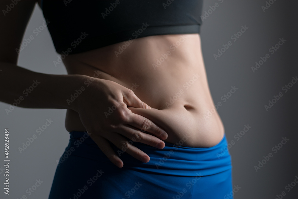 Fototapeta premium Woman holding and pushing the skin of the stomack cellulite.