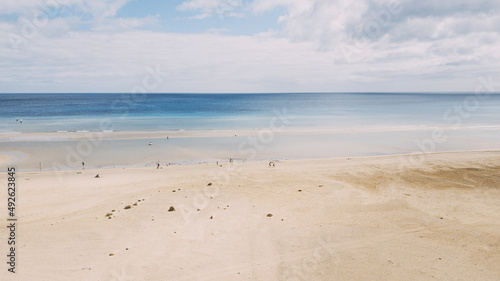 Amazing tropical sand beach with blue transparent sea water and sky in background. Tourism and tourists travel destination for summer holiday vacation. Copy space and beautiful landscape