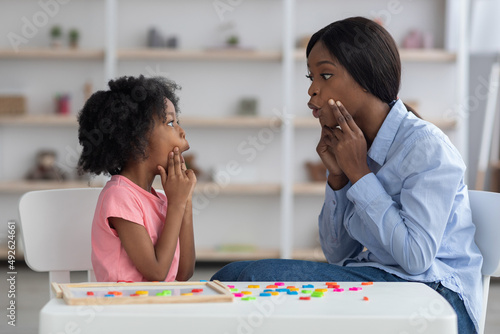 Cuadro en lienzo Speech-language pathologist having lesson with little girl
