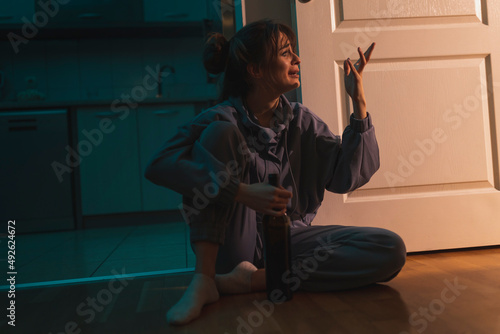 Depressed woman drinking wine from a bottle
