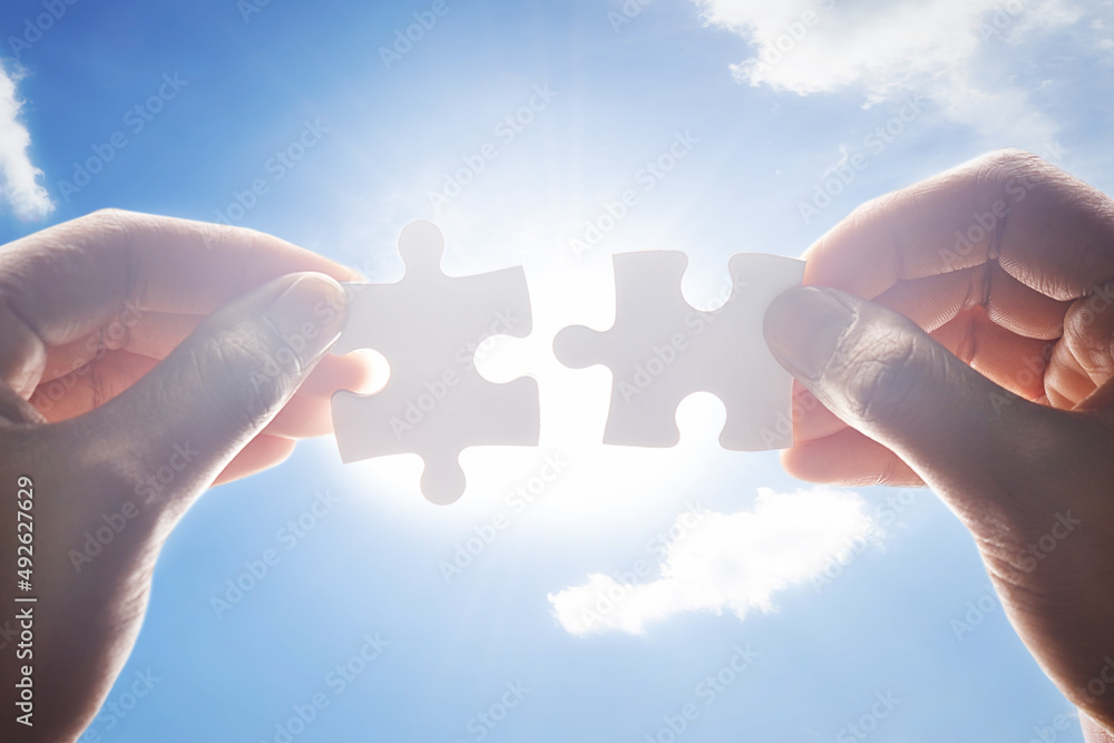 Together the make the perfect fit. Cropped shot of hands holding two puzzle pieces. Together the make the perfect fit. Cropped shot of hands holding two puzzle pieces.