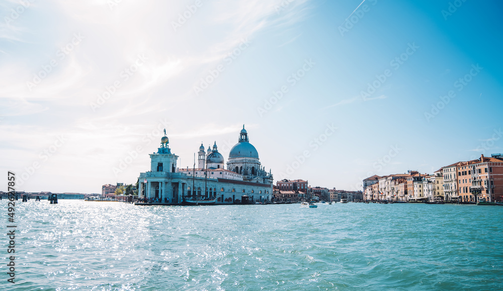 Landscape of Grand Canal and ancient Basilica Santa Maria della Salute in Venice during bright summer daytime, cityscape view on Italian romantic city for visiting during recreation vacations