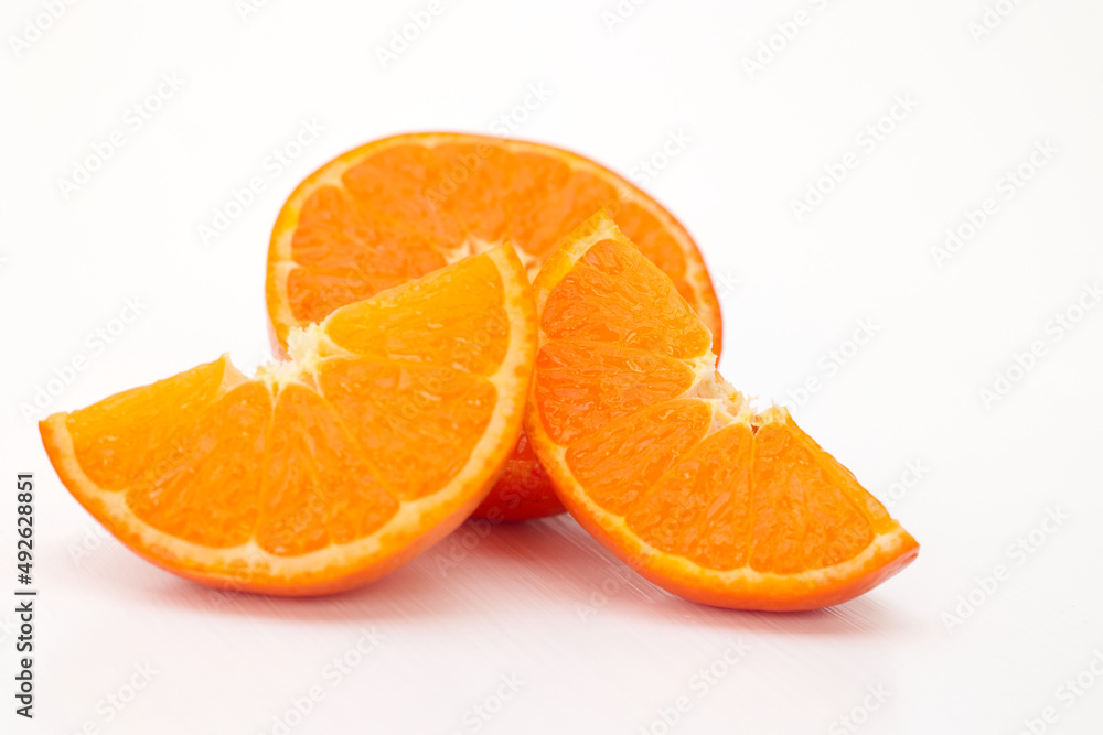 Closeup a group of ripe orang mandarin, clementine cut half slice isolated on white background, cross section organic tangerines two piece standing front a half orange sliced. citrus tropical fruit Closeup a group of ripe orang mandarin, clementine cut half slice isolated on white background, cross section organic tangerines two piece standing front a half orange sliced. citrus tropical fruit