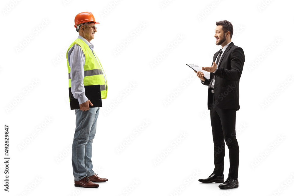 Businessman holding a document and talking to a mature male engineer Businessman holding a document and talking to a mature male engineer