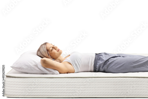 Young blond woman sleeping on a bed mattress