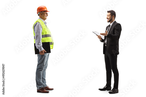 Businessman holding a document and talking to a mature male engineer