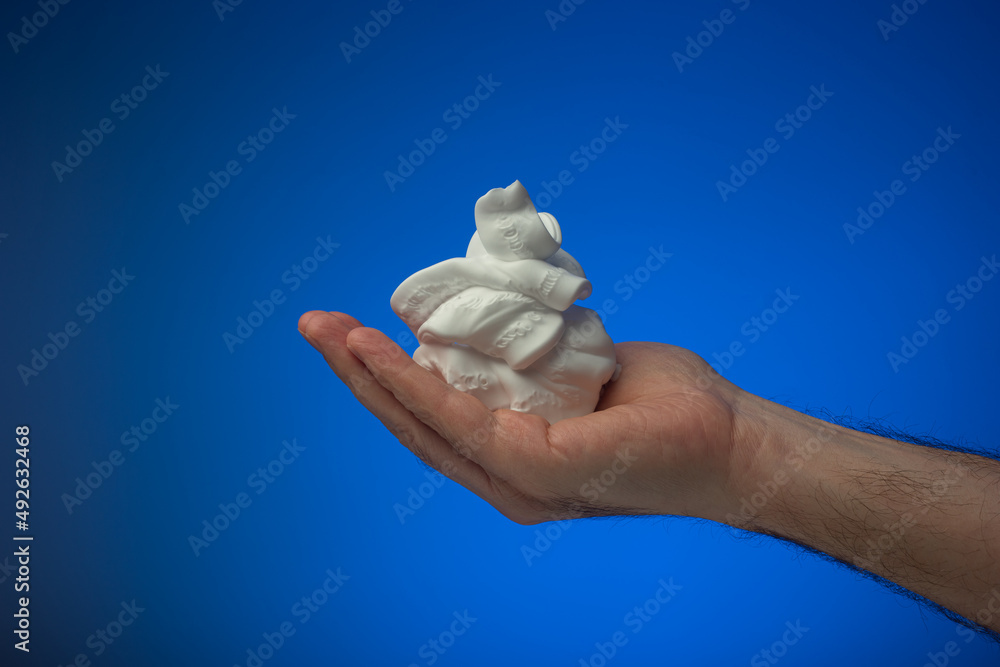White shaving foam held in palm by Caucasian male. Close up studio shot, isolated on blue background White shaving foam held in palm by Caucasian male. Close up studio shot, isolated on blue background