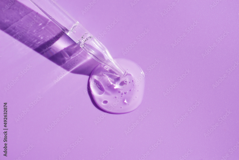 Pipette close-up on a purple background in soft focus. Beautiful shadow in the sunlight. Skincare products , natural cosmetic. Beauty concept for face and body care