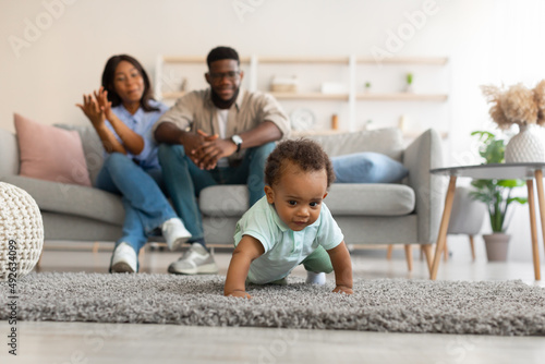 Cute baby toddler walking in living room making first steps