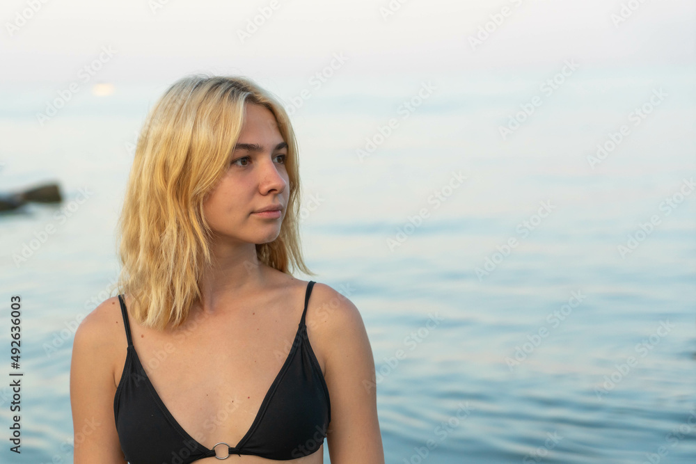 Young blonde woman on a rocky seashore after sunset. Odessa. Ukraine. Young blonde woman on a rocky seashore after sunset. Odessa. Ukraine.