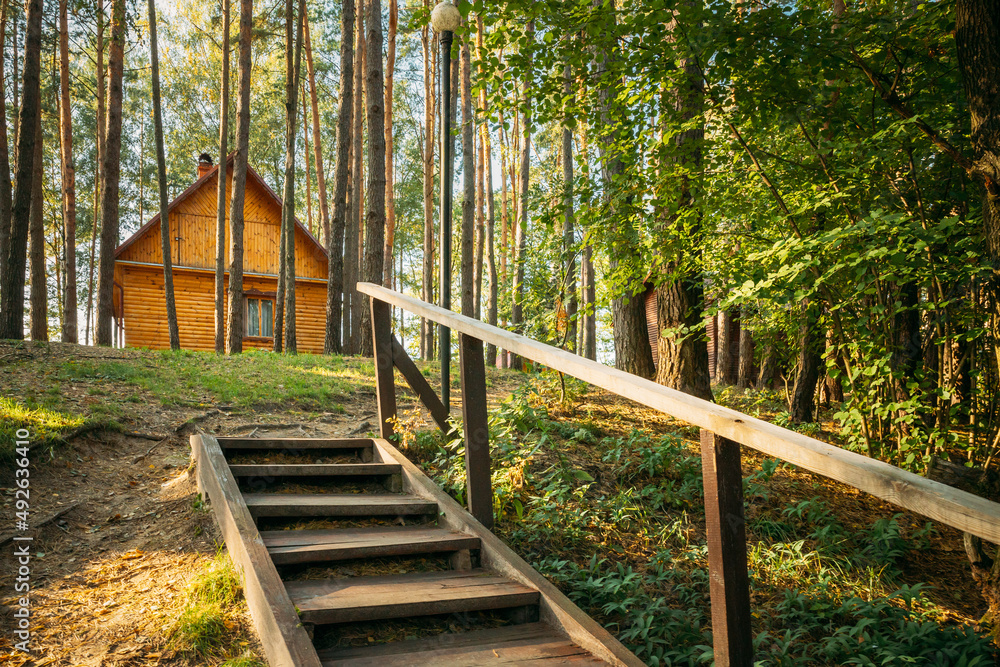 Tourist Guest House For Rest. Wooden House In Forest In Autumn Sunny Day. Wooden Boarding Path Way Pathway Leading To Tourist House. Resort In Wooden Guest House. Tourist Guest House For Rest. Wooden House In Forest In Autumn Sunny Day. Wooden Boarding Path Way Pathway Leading To Tourist House. Resort In Wooden Guest House.