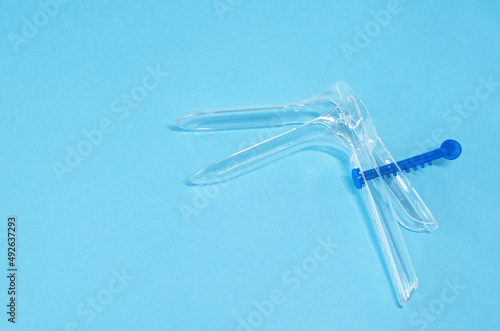 Disposable gynecological dilator for vaginal examination on blue background. Gynecological examination. Flat lay. photo