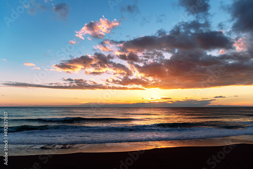 Beautiful panoramic seascape with golden sunset. Dramatic sky with clouds over sea in the evening.