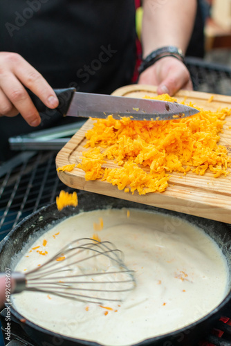 queso cheddar amarillo rallado y agregado en sarten para preparar salsa de quesoqueso cheddarquesocheddar 