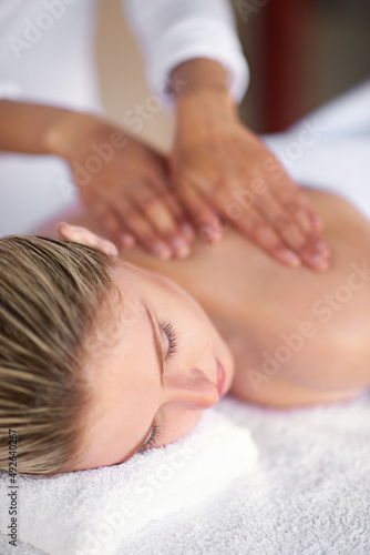 Where stress ends and relaxation begins.... Shot of a young woman enjoying a massage at the spa.