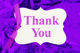 Thank you gift tag over colorful purple glossy paper