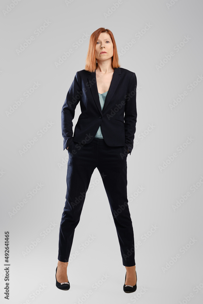 Stylish middle aged woman in pantsuit posing in studio Stylish middle aged woman in pantsuit posing in studio