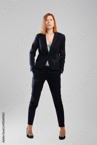 Canvas Print Stylish middle aged woman in pantsuit posing in studio