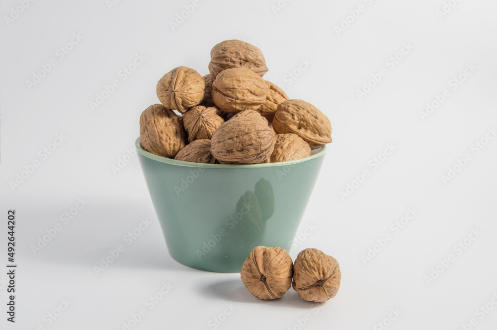 bowl with walnuts and two outside, isolated on white background bowl with walnuts and two outside, isolated on white background