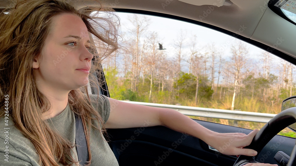 Young woman driving a car - close up shot - travel photography Young woman driving a car - close up shot - travel photography