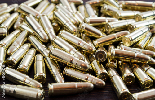 Golden pistol bullets on a wooden background